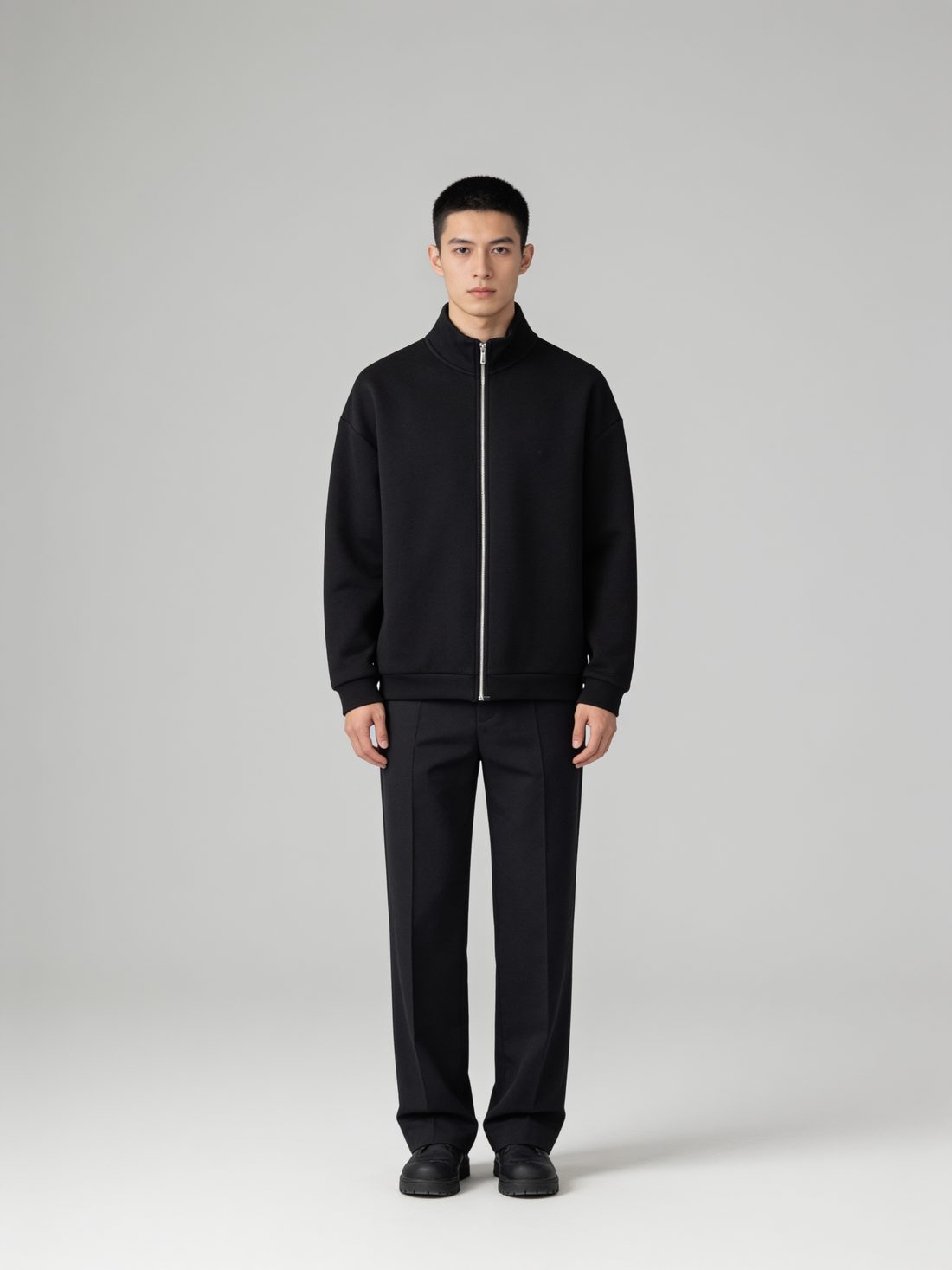 Model in a black scuba-knit zip jacket